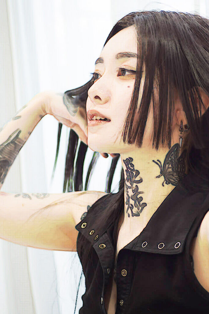 タトゥーを強調するために加工した女性の写真。髪をかき上げている横顔。喉元には漢字の、首元には蝶のタトゥーが見える。